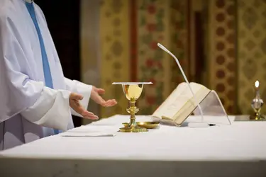 Prêtre présentant le pain et le vin pendant la messe - crédits : © Lightpoet/ Shutterstock